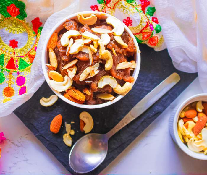 Overhead image of Singhare Ke atte ka halwa on a black plate with white cloth in the back