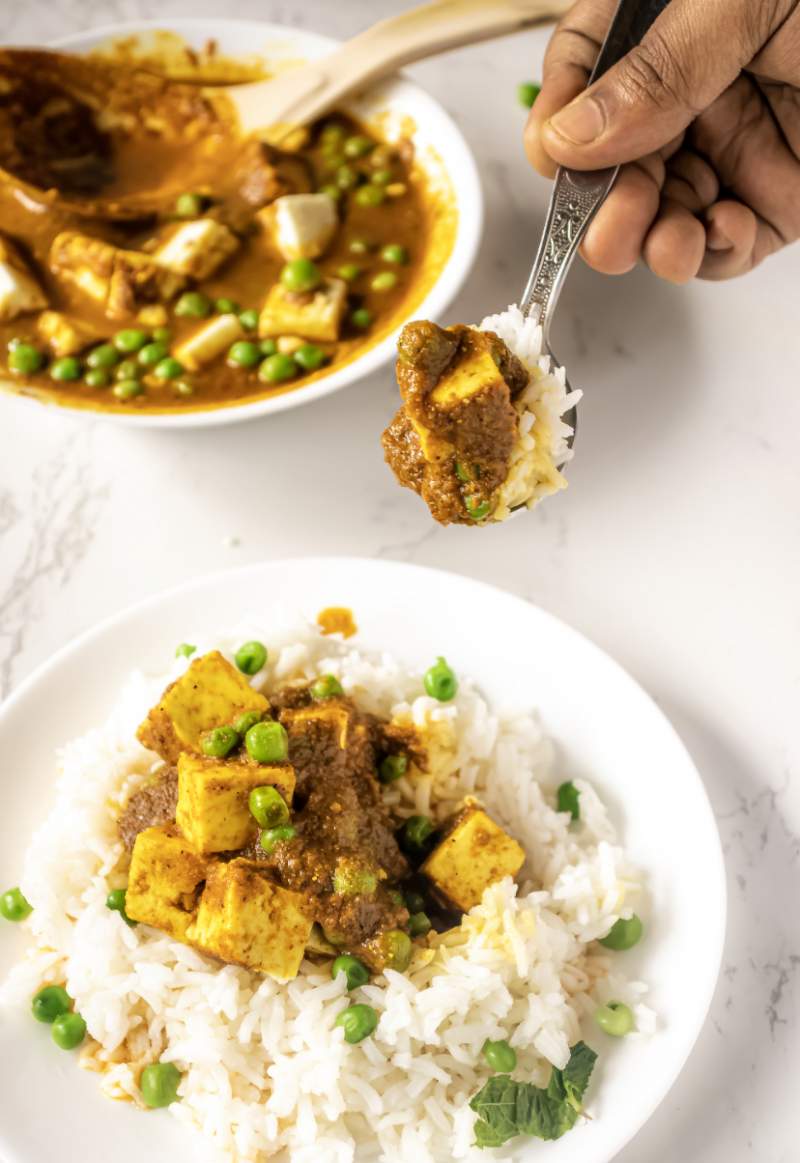 Picking up a spoonful of the Matar Paneer and rice