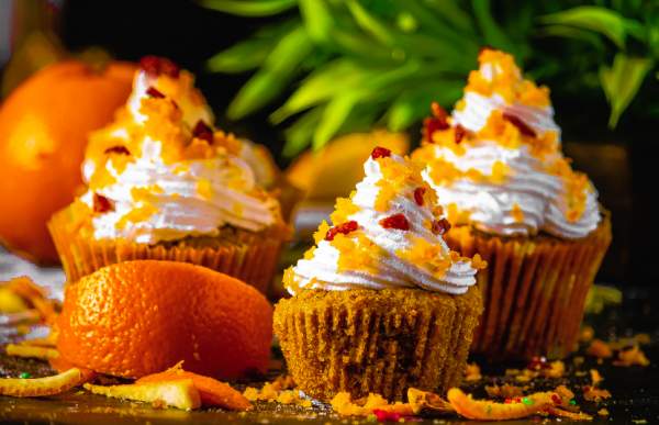 square image of Orange Cranberry Cupcakes on a black table 