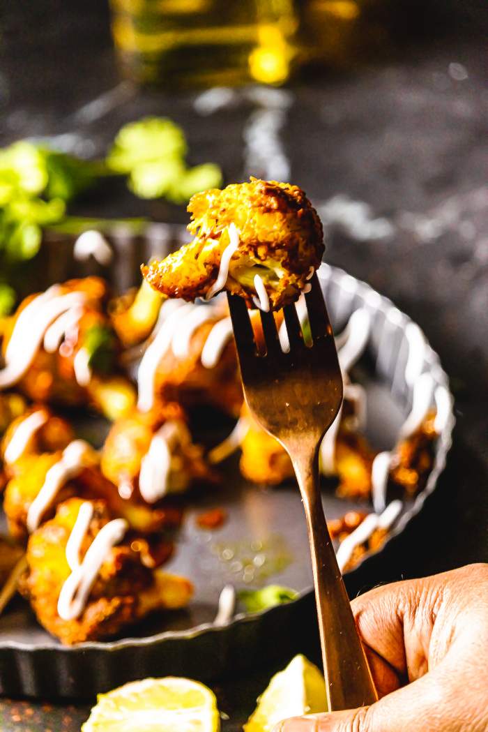 tandoori gobi in a fork with others in the back