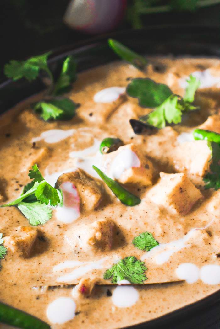 closeup of White Reshmi Paneer Recipe with cilantro and paneer cubes