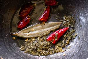 adding whole spices in a pan with oil