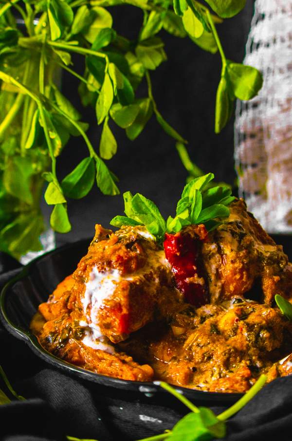 Methi Malai Chicken served on a black plate
