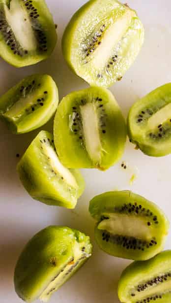 chopped kiwi kept on a white cutting board